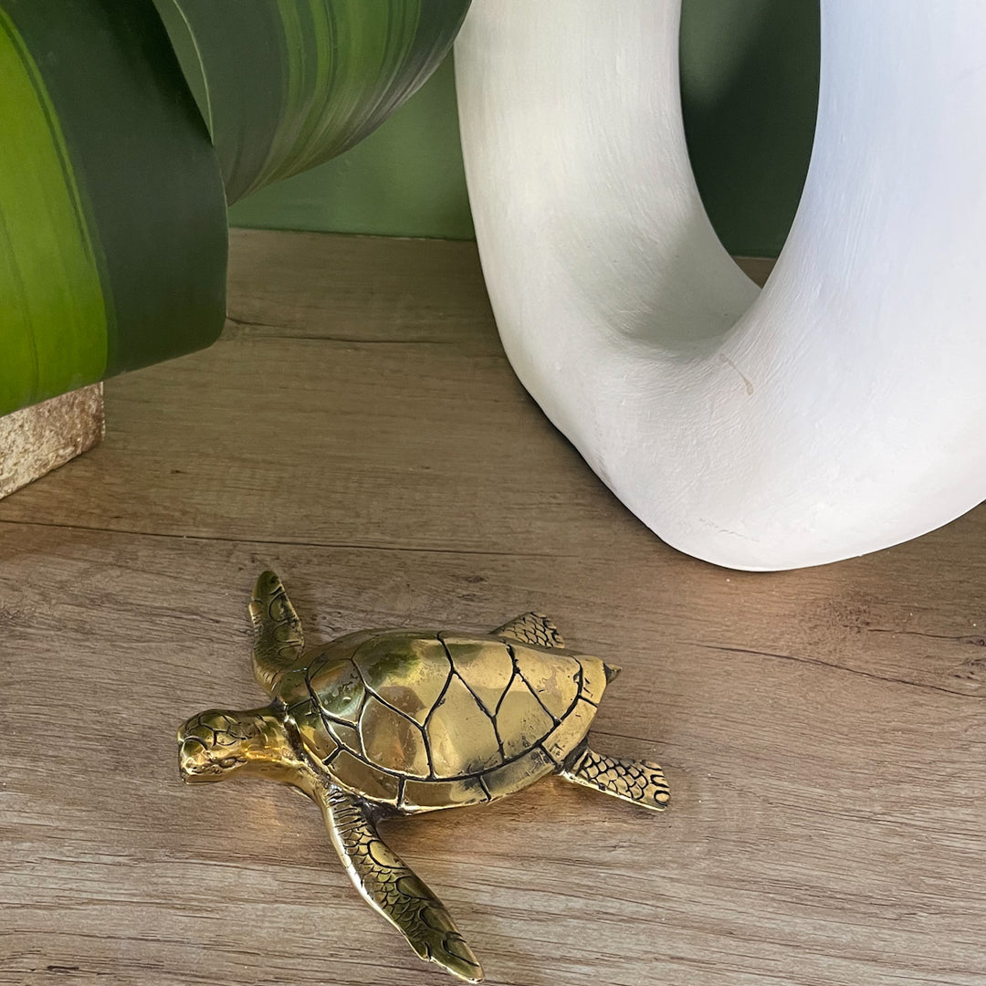 Brass Turtle Figurine on table by vase by Ocean Luxe